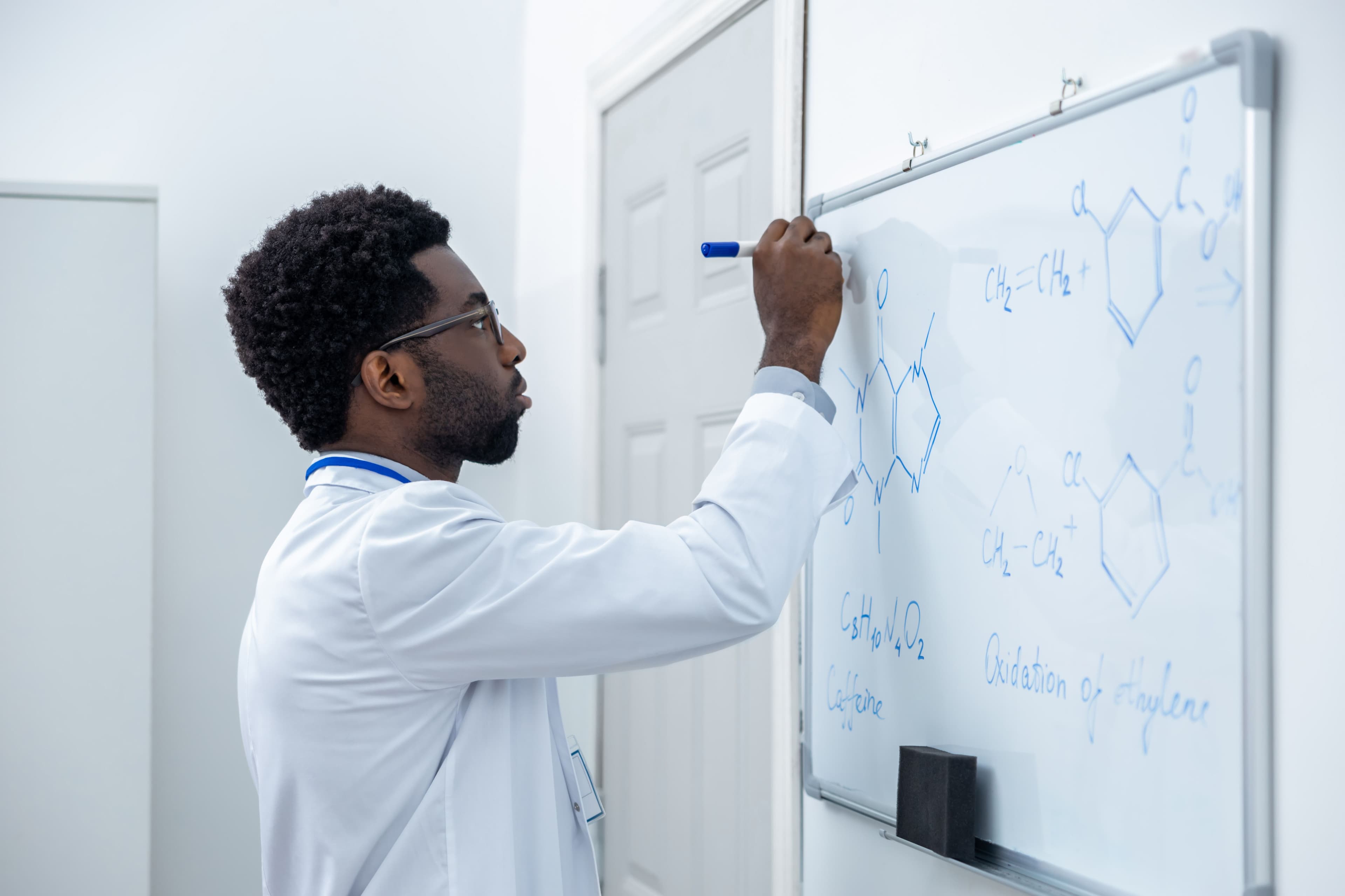 Male teacher drawing chemical diagrams